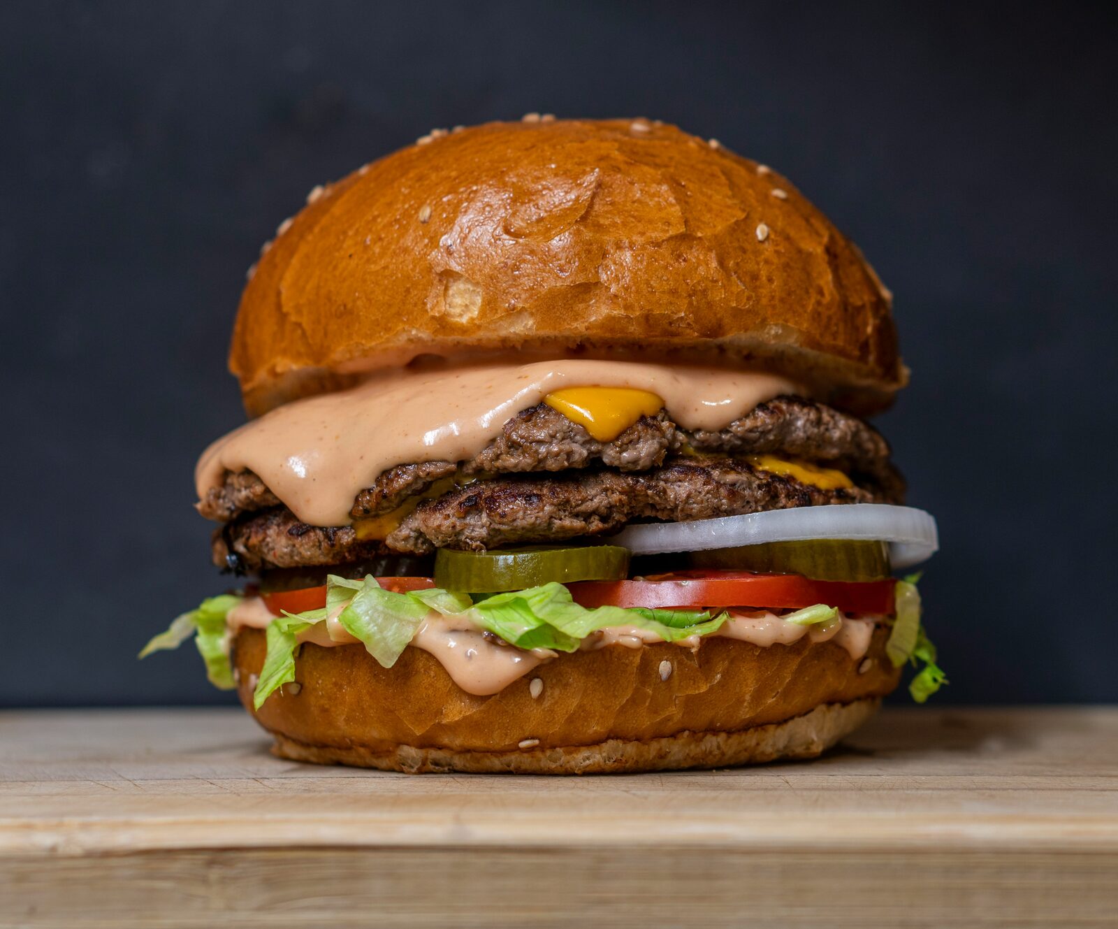 Double cheeseburger against a near-black background