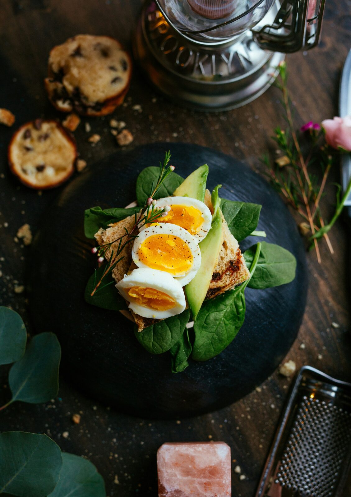 Soft-boiled eggs on toast styled with greens in directional light